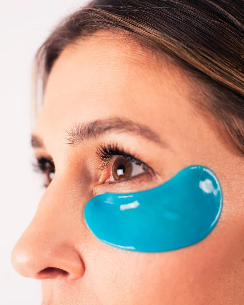 Close-up of a woman wearing blue Eye Bright Masks under her eye highli