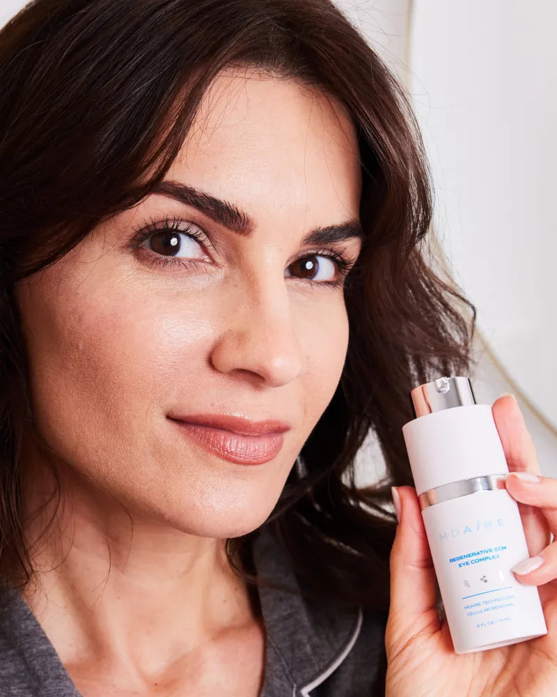 Woman holding Regenerative ECM Eye Complex bottle in gallery position 