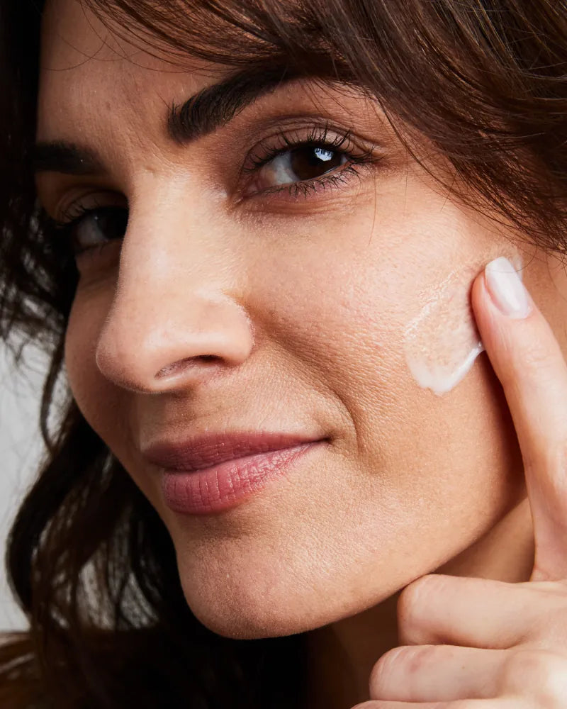 Woman applying NMF Hydrator Barrier Repair developed by Dr. Stefani Ka