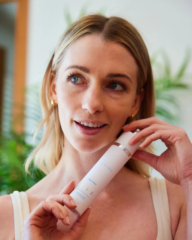 Woman holding Neck Tyte-R moisturizer near her neck showing skincare b