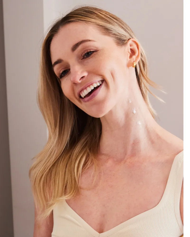Smiling woman with moisturizer applied to neck demonstrating Neck Tyte