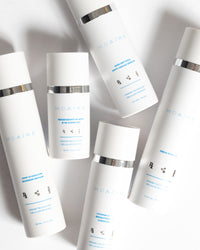Skincare Essentials Bundle featuring sleek white bottles with silver accents highlighting advanced MDAiRE formulas gallery 1